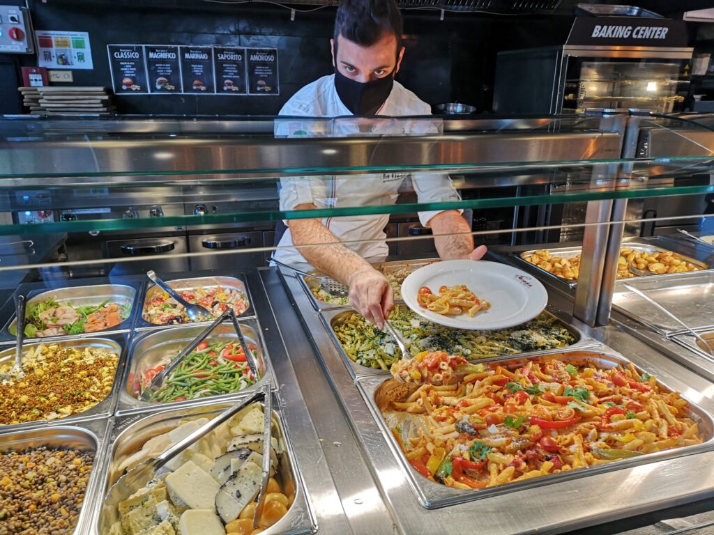 Employé préparant une assiette de pâtes fraîches à La Focacceria