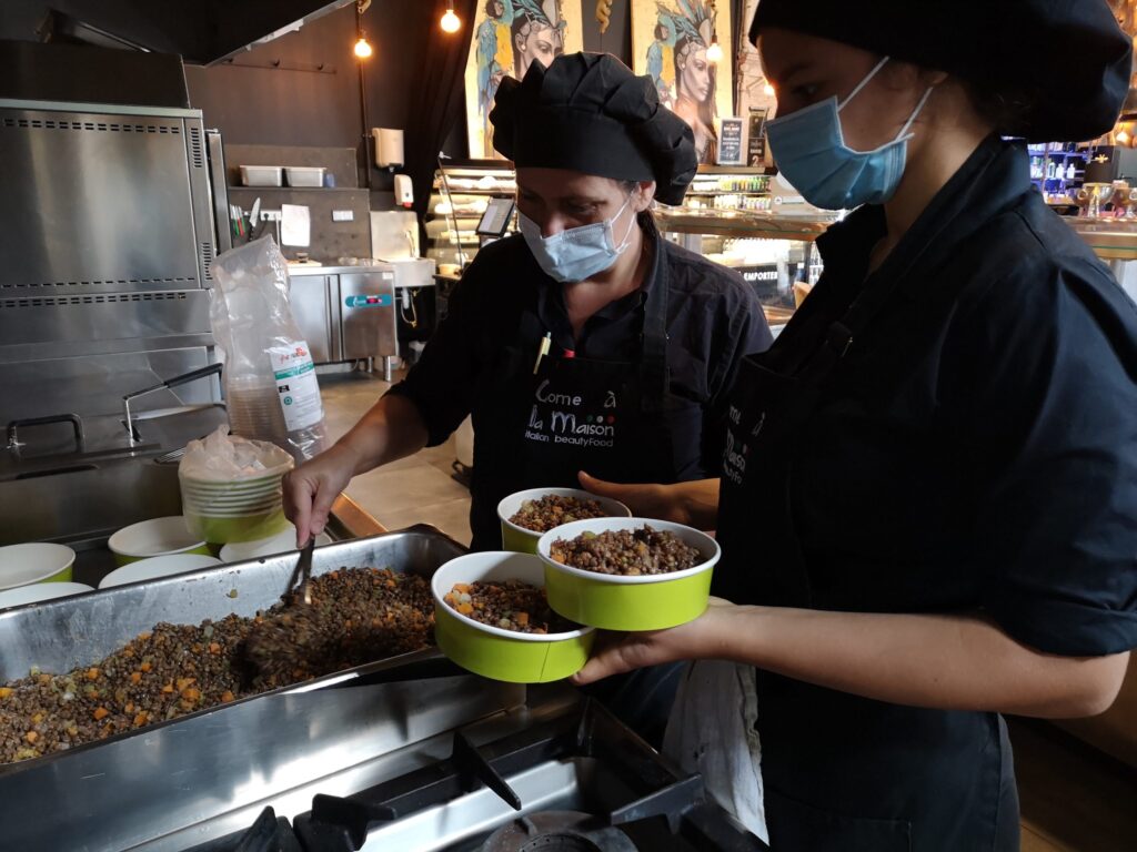 Employés de La Focacceria préparant et remplissant des plats traiteurs